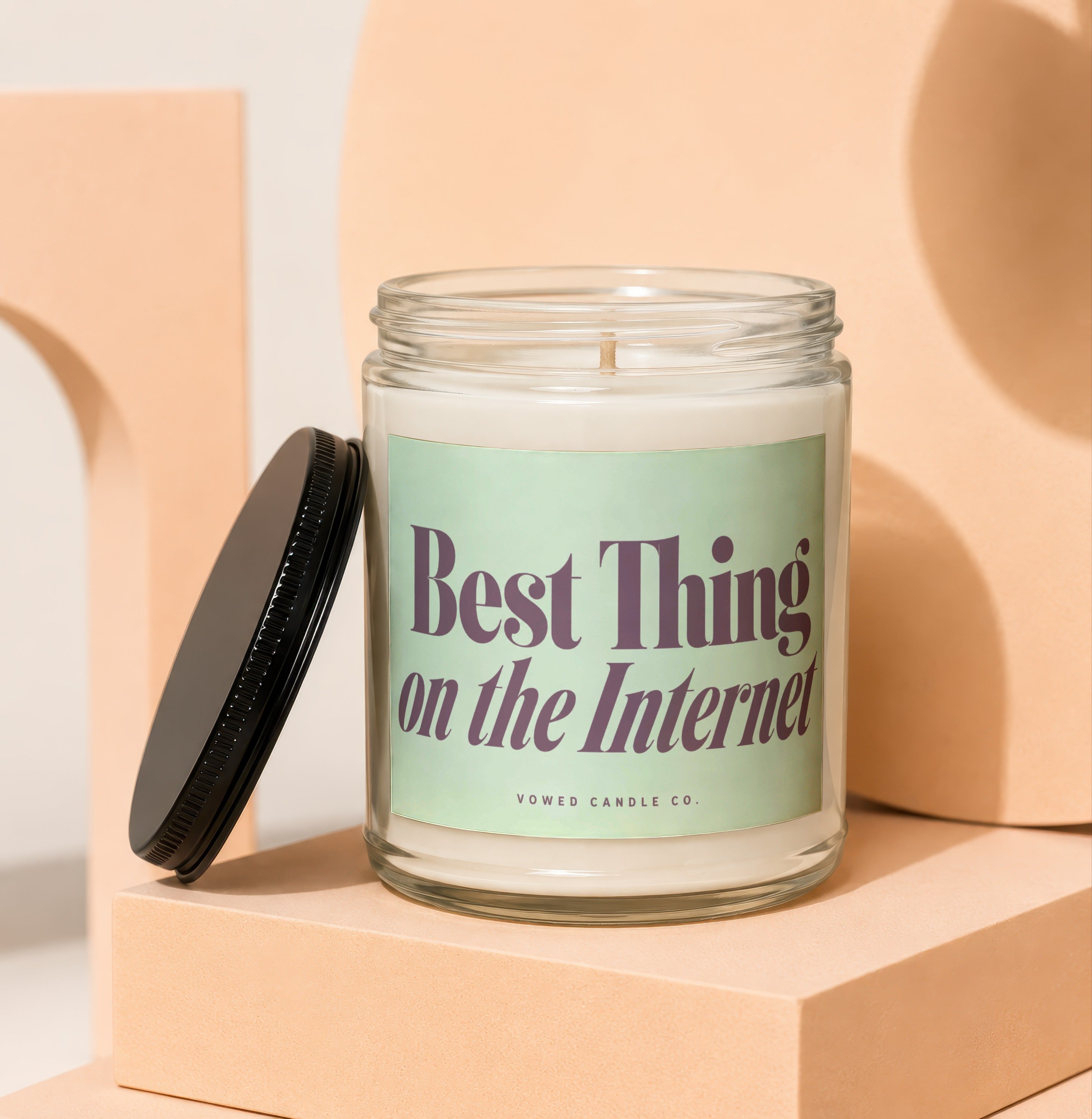 Glass candle with light green label that reads "Best Thing on the Internet"