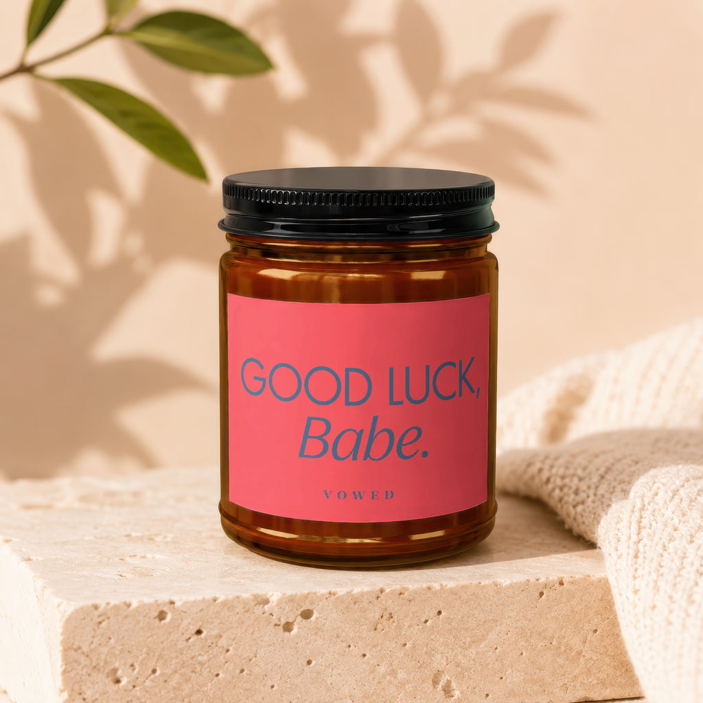 Amber jar candle with pink label that reads "GOOD LUCK, Babe."