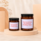 Two amber glass candles with white labels reading "Thank You for Being the Calm in My Wedding Chaos."