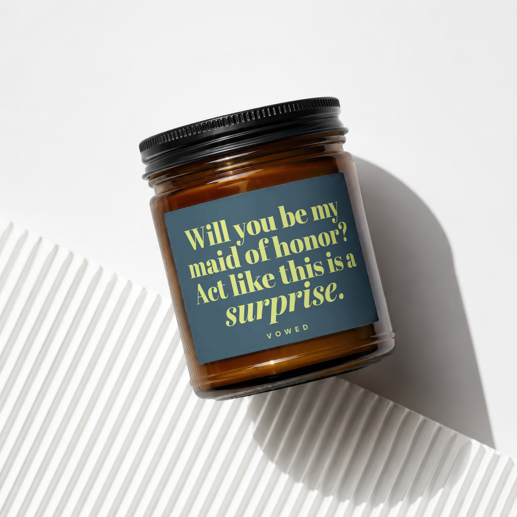 Amber jar candle with dark blue label asking "Will you be my maid of honor?"