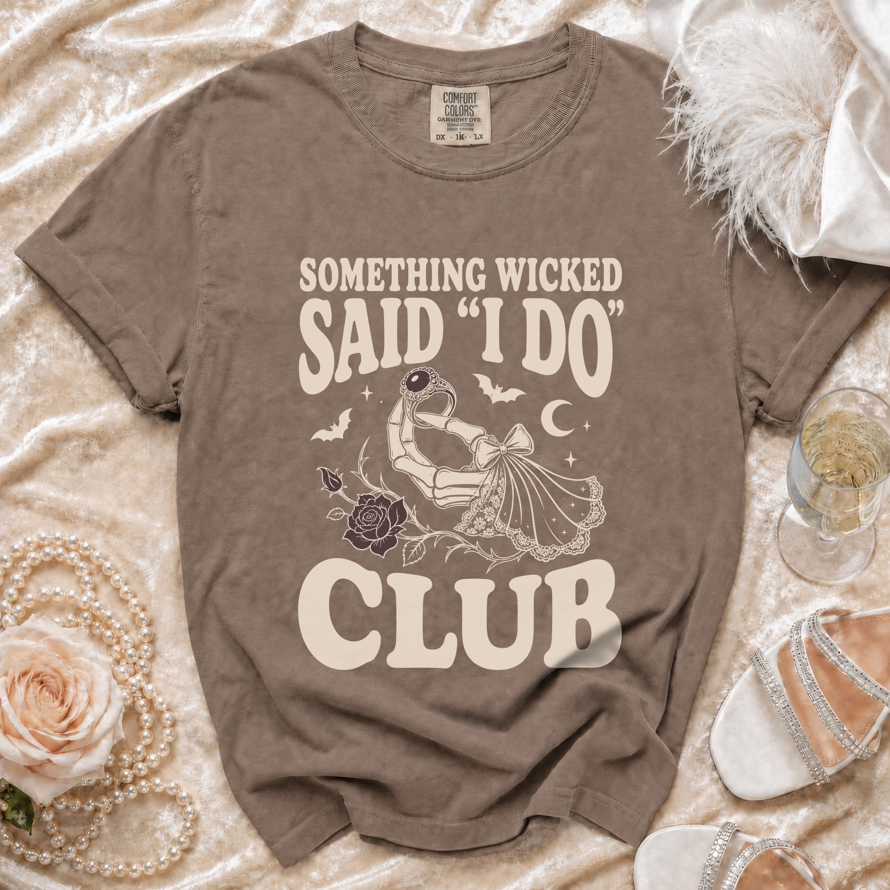 T-shirt with text "Something Wicked Said 'I Do' Club" and skeletal hand holding ring.