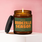 Amber glass candle with lit flame and green label reading "WARNING: BRIDEZILLA SEASON APPROACH WITH CAUTION AND CHAMPAGNE. VOWED".