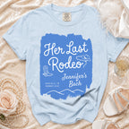 Light blue t-shirt with "Her Last Rodeo Jennifer's Bach" text and cowboy motifs.