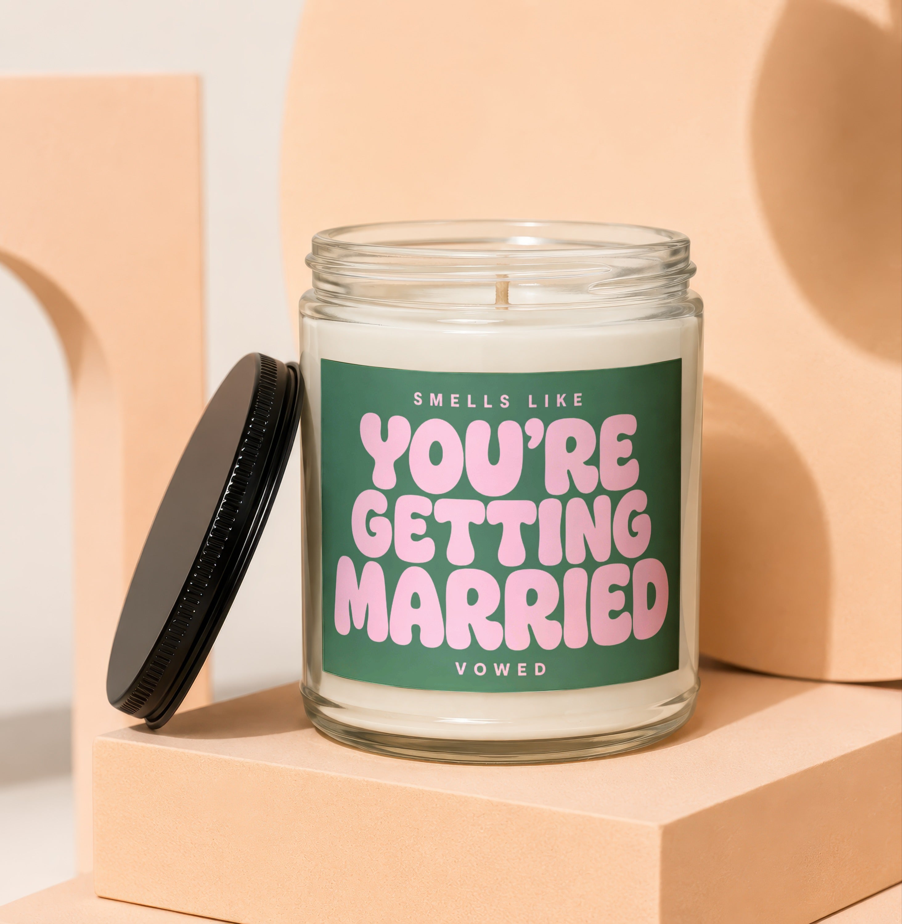 Scented candle with green label reading "Smells Like You're Getting Married"