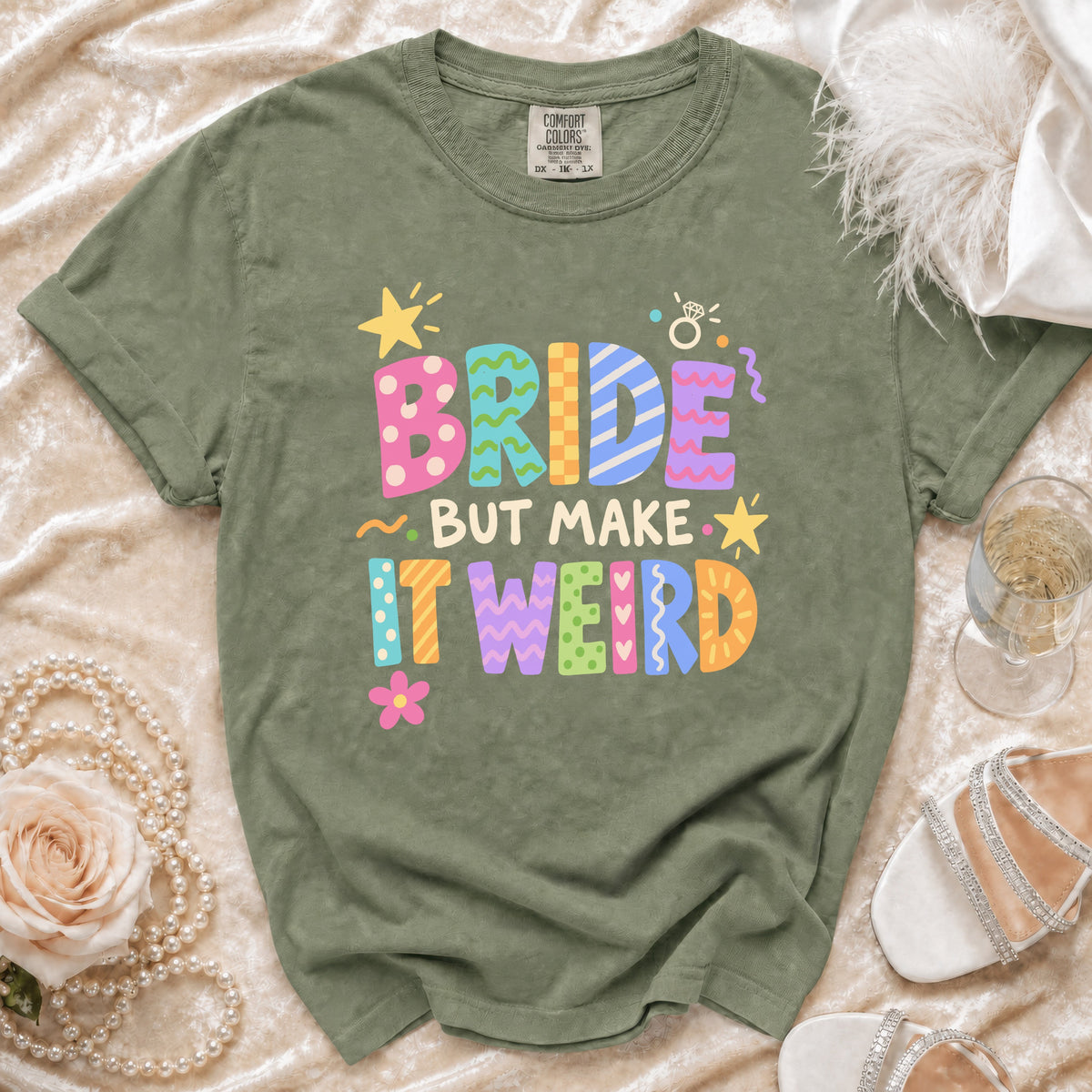 Green t-shirt with colorful "BRIDE BUT MAKE IT WEIRD" text and graphics.
