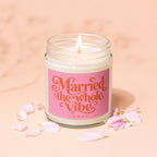 Lit candle in jar with pink label stating "Married the whole vibe VOWED".