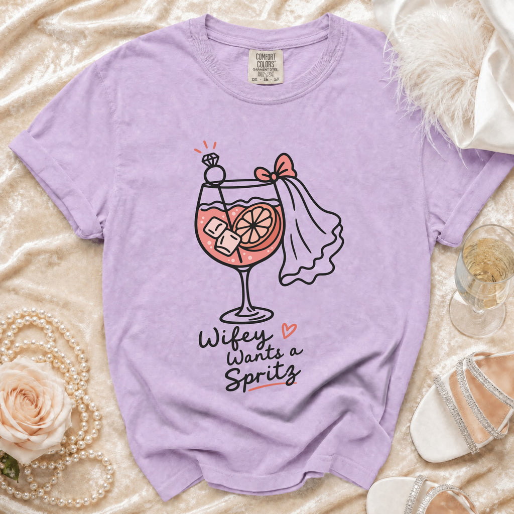 Lilac t-shirt with graphic "Wifey Wants a Spritz" and cocktail illustration.