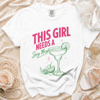 White t-shirt with pink and green "This girl needs a spicy margi" text and graphic.