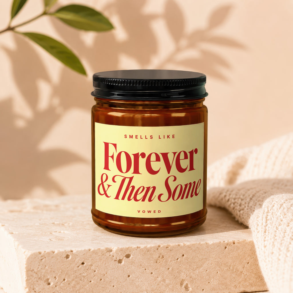Candle with yellow label reading "Smells Like Forever & Then Some Vowed".