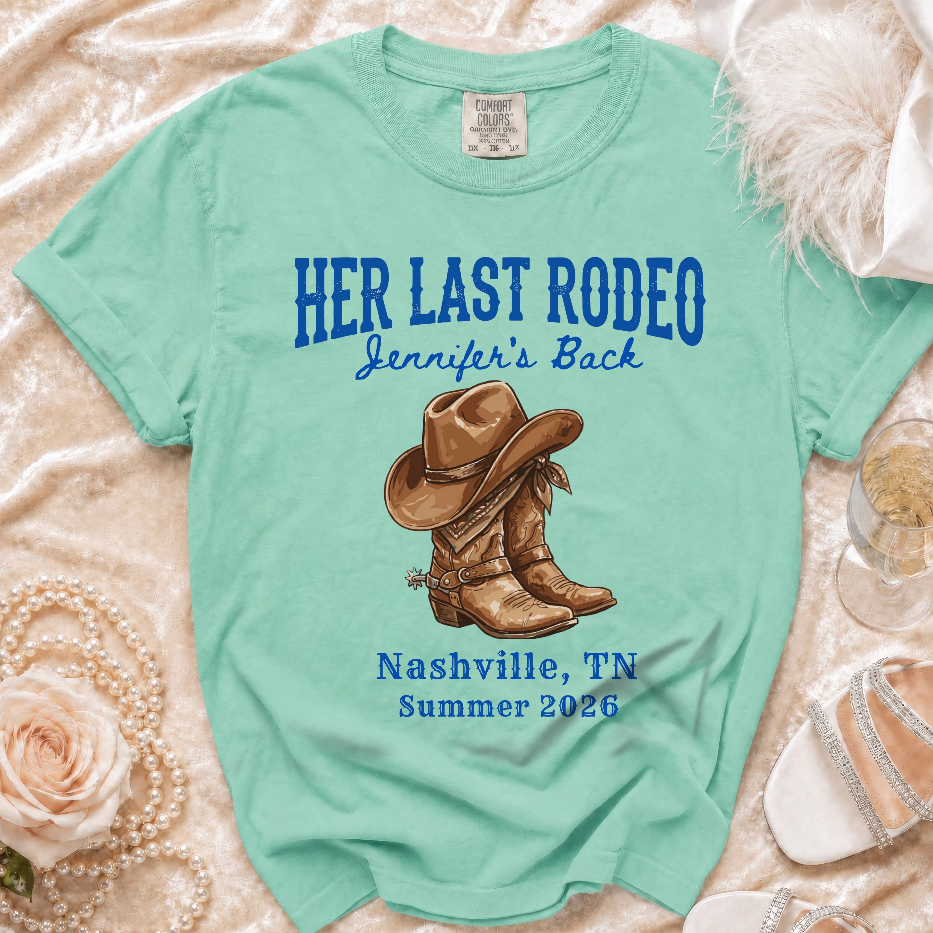 Turquoise t-shirt with "Her Last Rodeo Jennifer's Back" and cowboy boots.