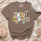 Brown t-shirt with "HONEY MOONING" text, airplane, and wedding rings graphic.