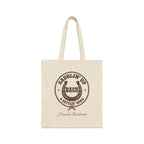 Off-white canvas tote bag with brown rodeo-themed text, horseshoe, and rope graphic on the front.