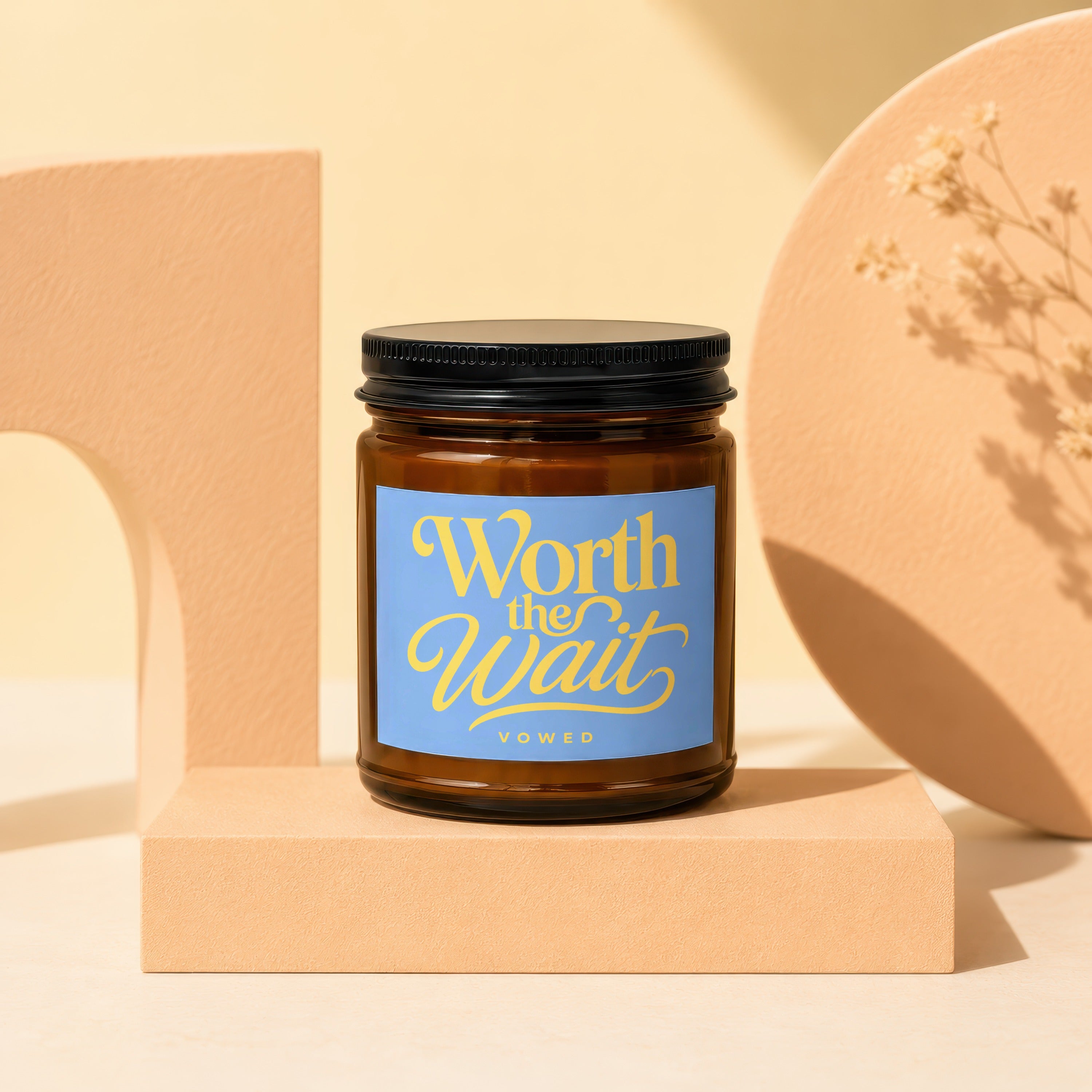 Brown amber glass candle with blue label reading "Worth the Wait VOWED".