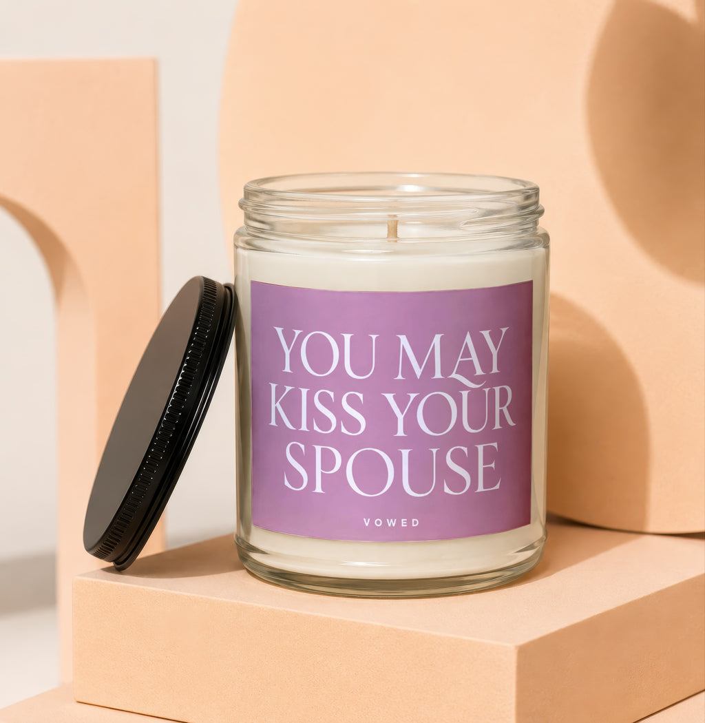Glass candle with "YOU MAY KISS YOUR SPOUSE" text on a purple label.