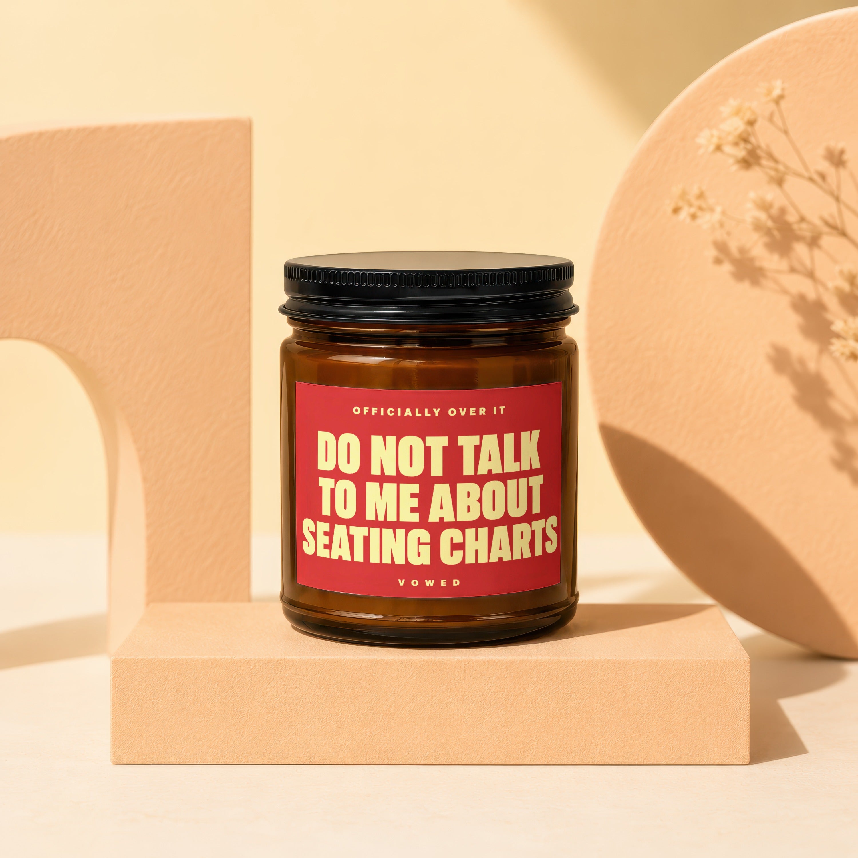 Amber candle with a red label reading "DO NOT TALK TO ME ABOUT SEATING CHARTS".