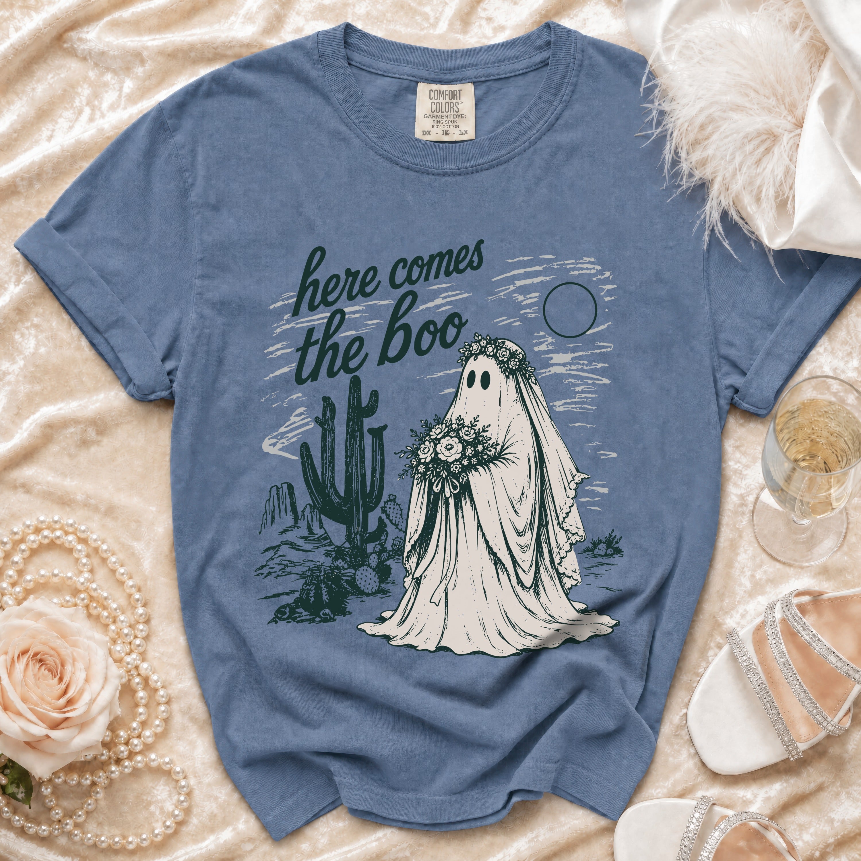 Blue Comfort Colors t-shirt with "here comes the boo" text and ghost bride in desert scene.