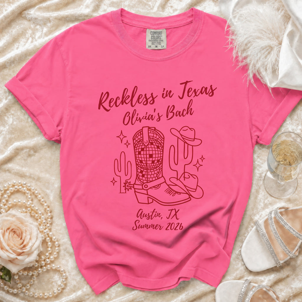 Pink t-shirt with "Reckless in Texas Olivia's Bach" and Texas-themed graphics.