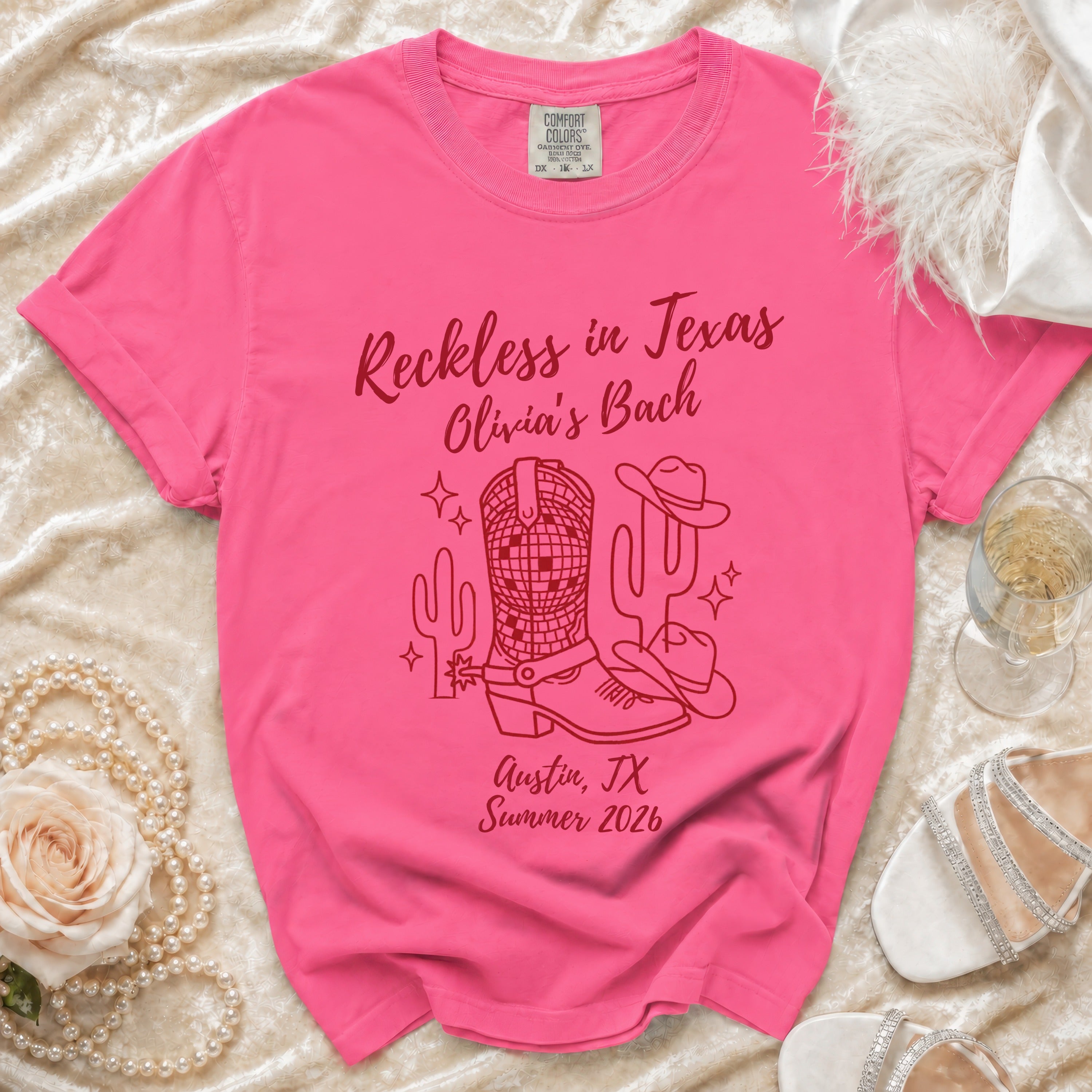 Pink t-shirt with "Reckless in Texas Olivia's Bach" and Texas-themed graphics.