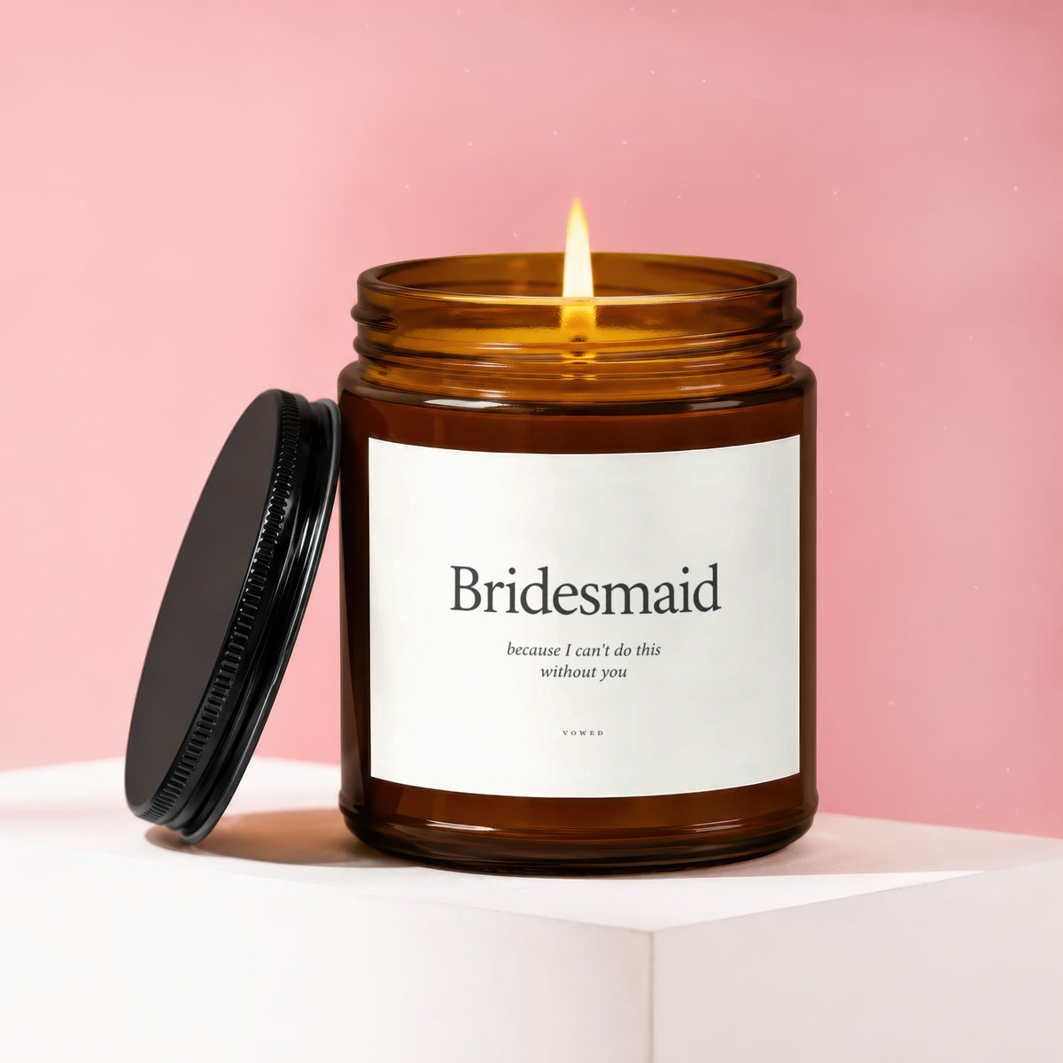 Brown glass candle lit with a white label that says "Bridesmaid"