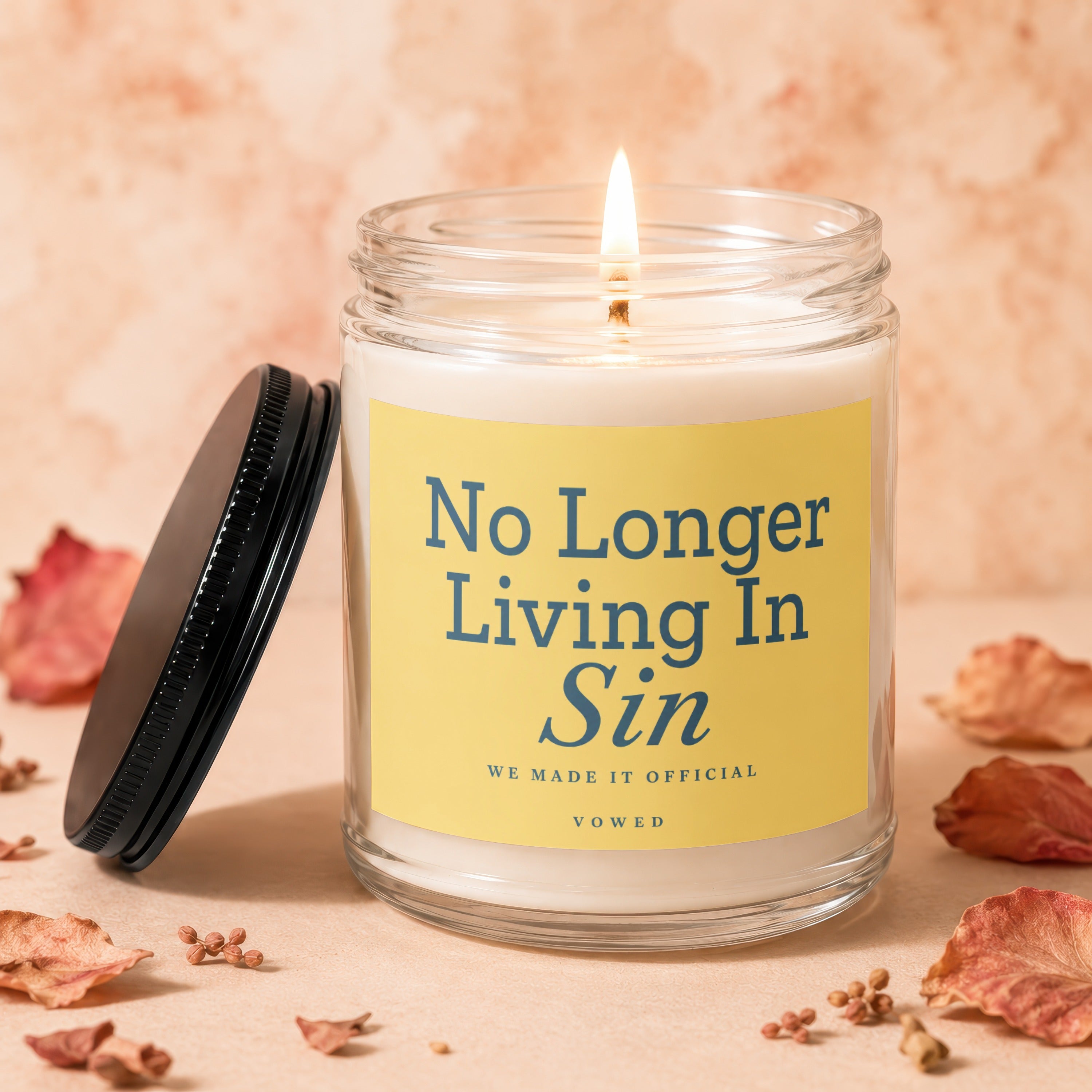Scented candle in glass jar with yellow label reading "No Longer Living In Sin".