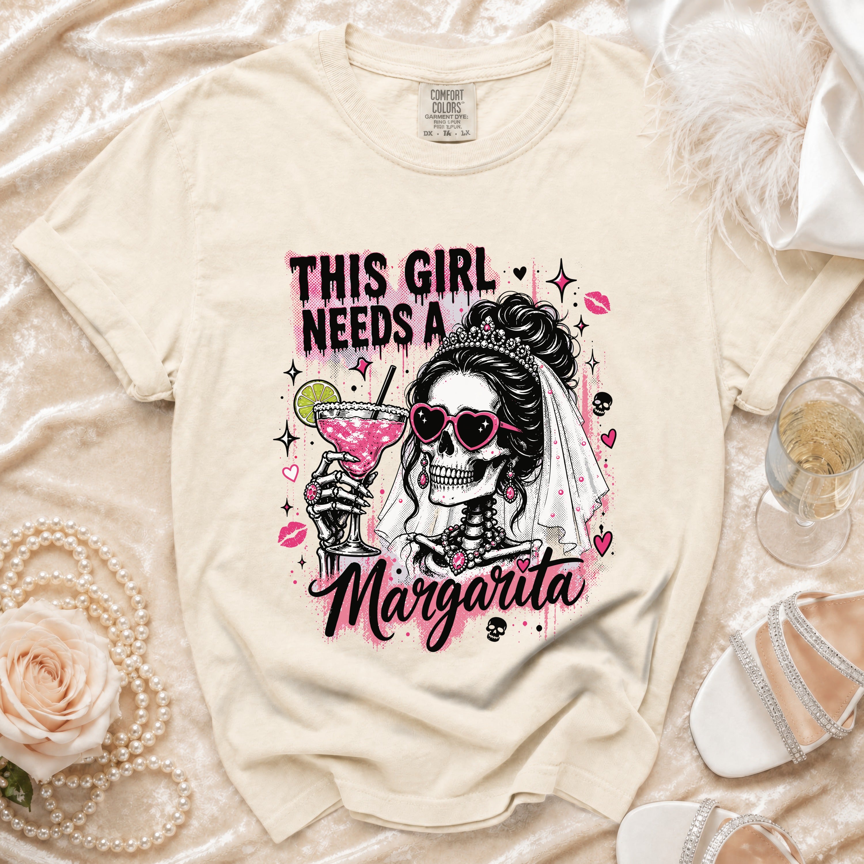 Cream graphic tee with skeleton bride holding margarita and text THIS GIRL NEEDS A MARGARITA.