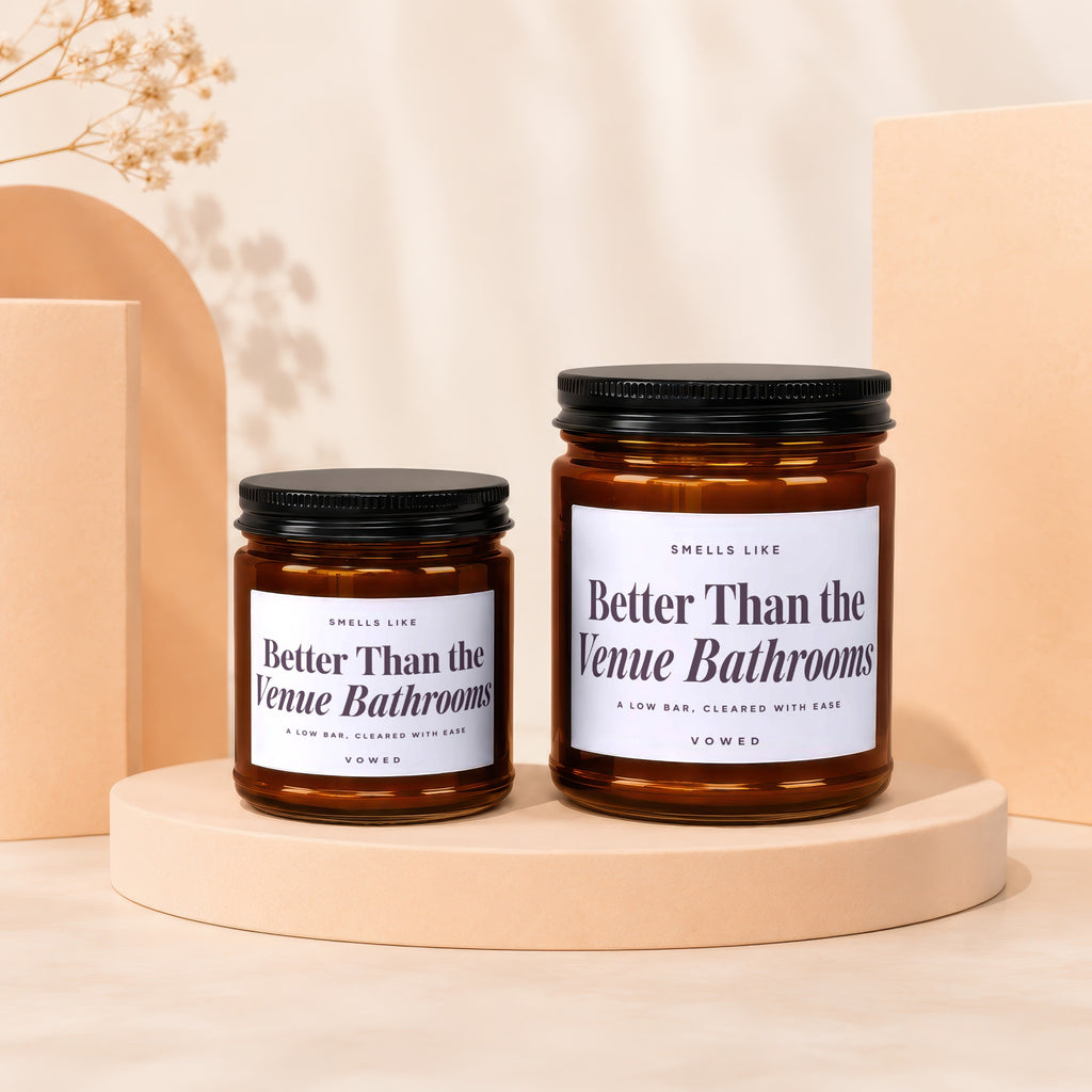 Two brown jar candles with black lids feature labels reading "Better Than the Venue Bathrooms".