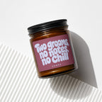 Amber jar candle with burgundy label reading "Two grooms, no notes, no chill".