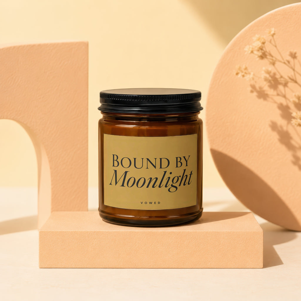 Brown glass candle labeled "BOUND BY Moonlight" with a black lid.