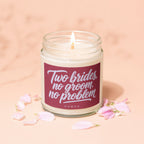 Candle with "Two brides, no groom, no problem" text and pink petals.