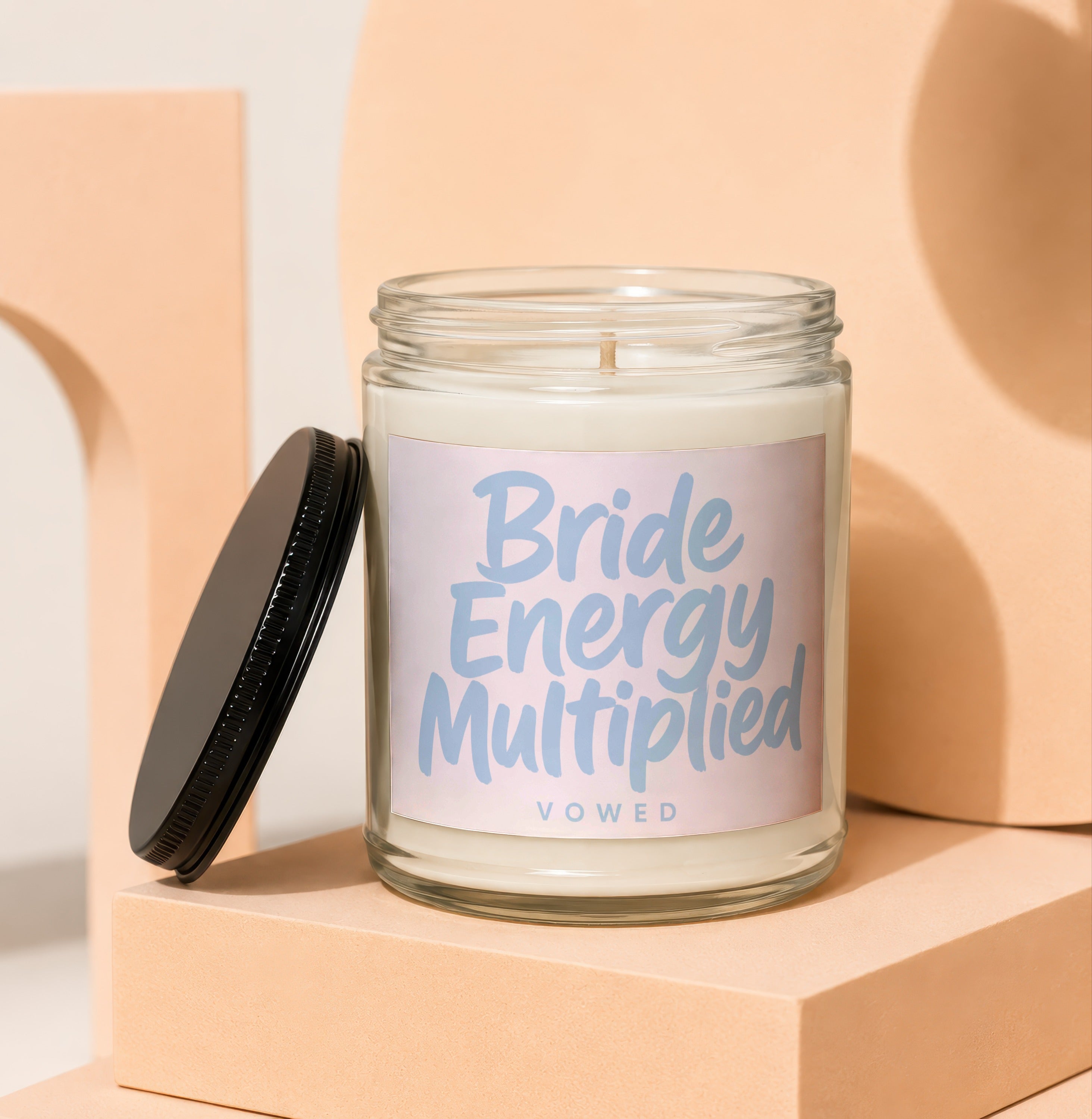 Glass candle with "Bride Energy Multiplied" and "VOWED" text on label.
