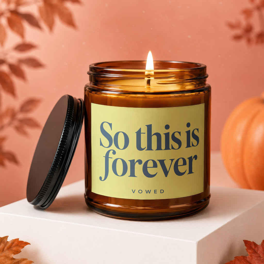 Amber jar candle with lit wick, lid off, and text "So this is forever"