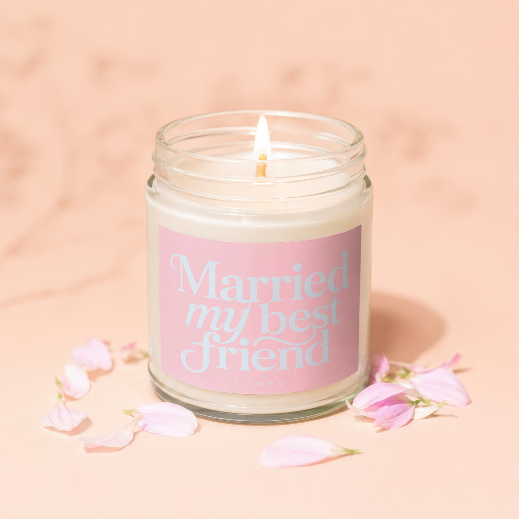 Lit candle with pink label reading "Married my best friend" and "VOWED".