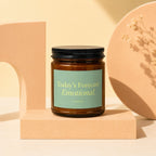 Brown glass candle with black lid and light green label reading "Today's Forecast: Emotional."