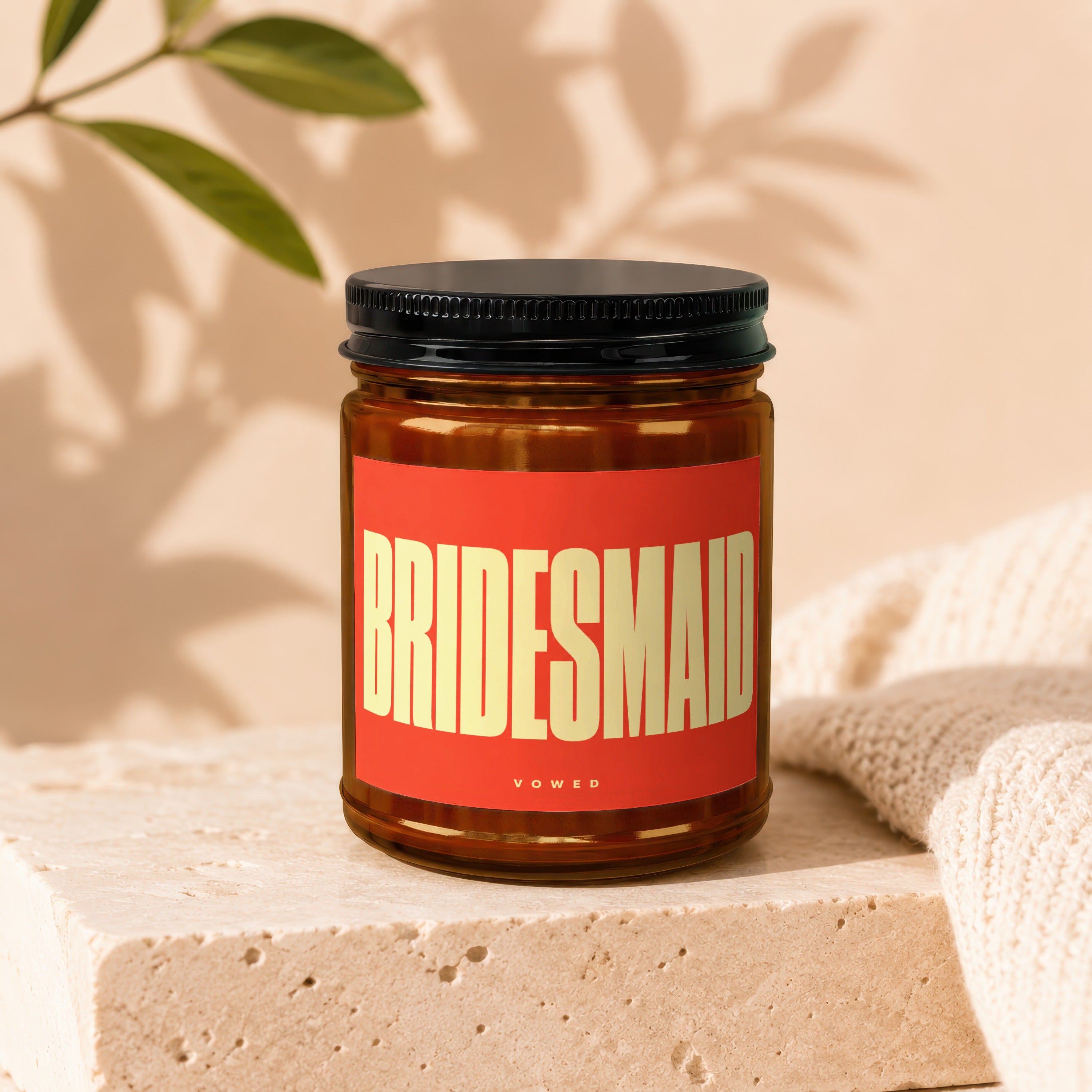 Amber jar candle with red label reading "BRIDESMAID" and "VOWED".