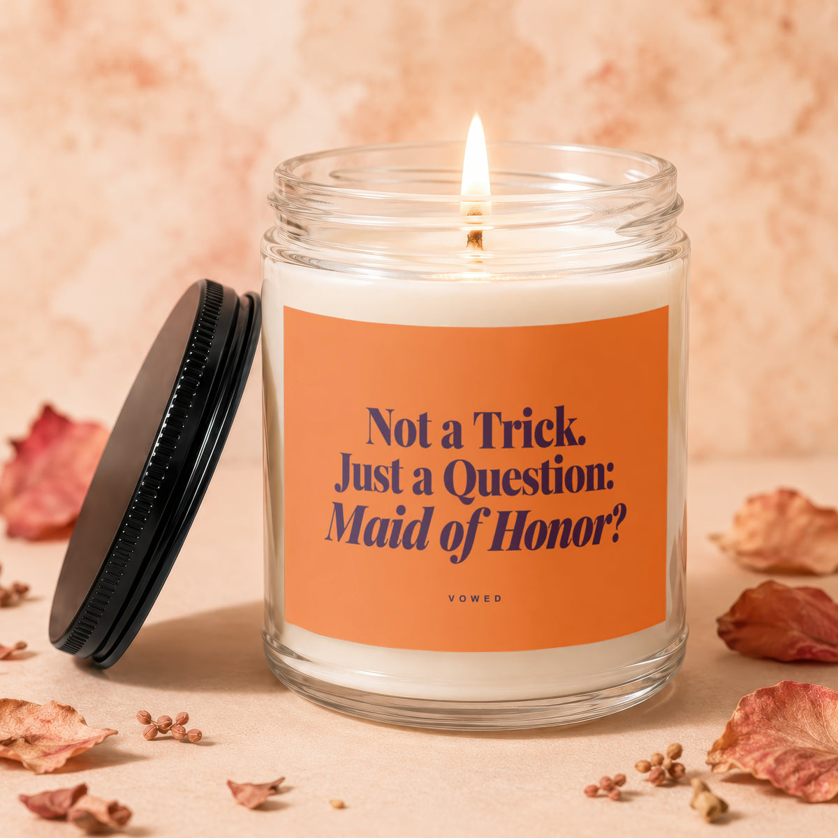 Candle with orange label reading "Not a Trick. Just a Question: Maid of Honor?"
