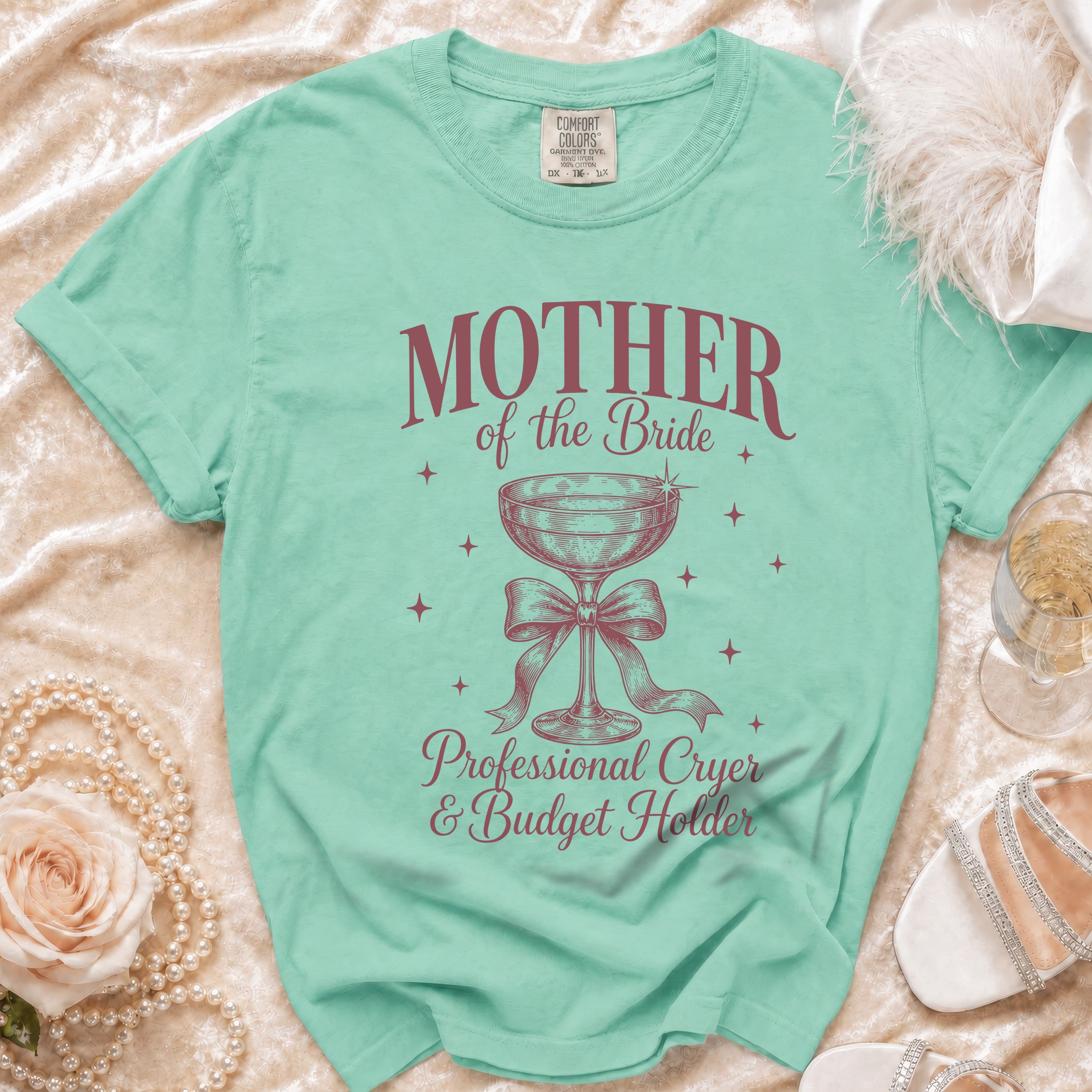 Mint green t-shirt with "Mother of the Bride" text and champagne glass graphic.