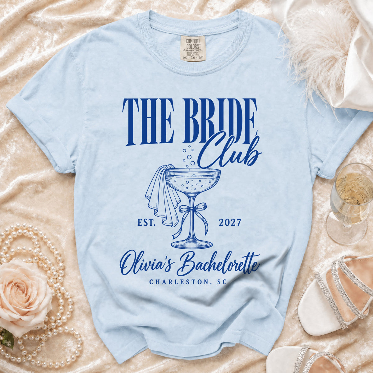 Light blue t-shirt with blue text reading The Bride Club Olivia's Bachelorette Charleston, SC.