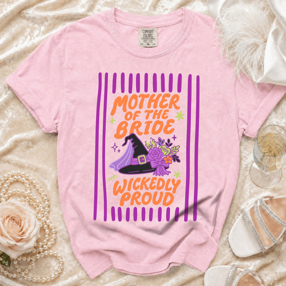 Pink t-shirt with "Mother of the Bride Wickedly Proud" text and witch hat graphic.