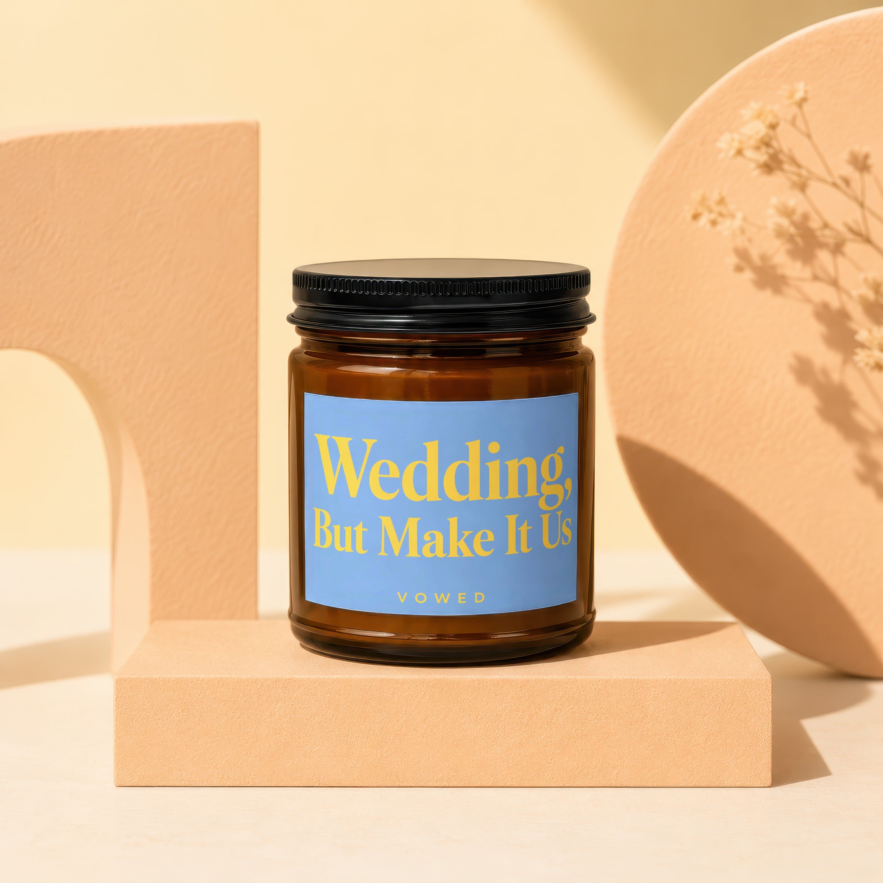 Amber glass candle with blue label reading "Wedding, But Make It Us".