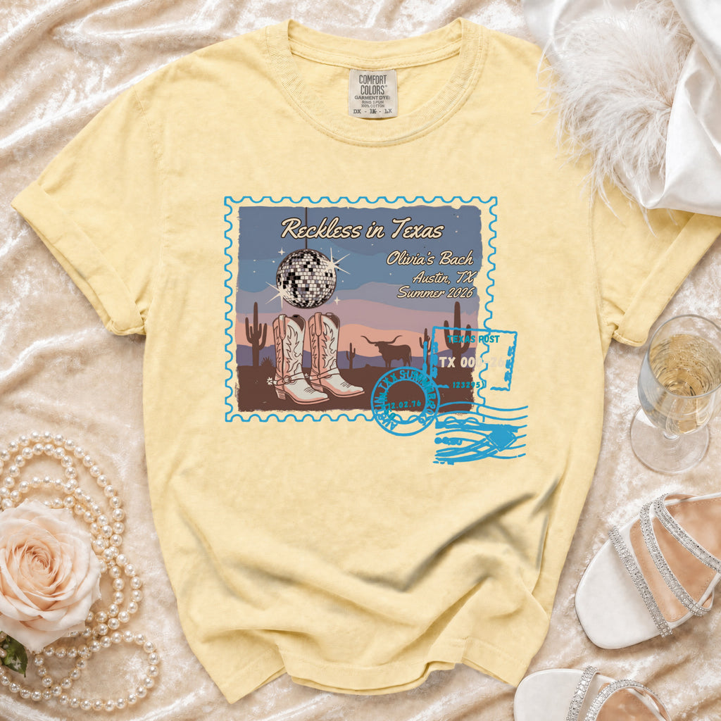 T-shirt with "Reckless in Texas" graphic featuring cowboy boots, disco ball, and cityscape.