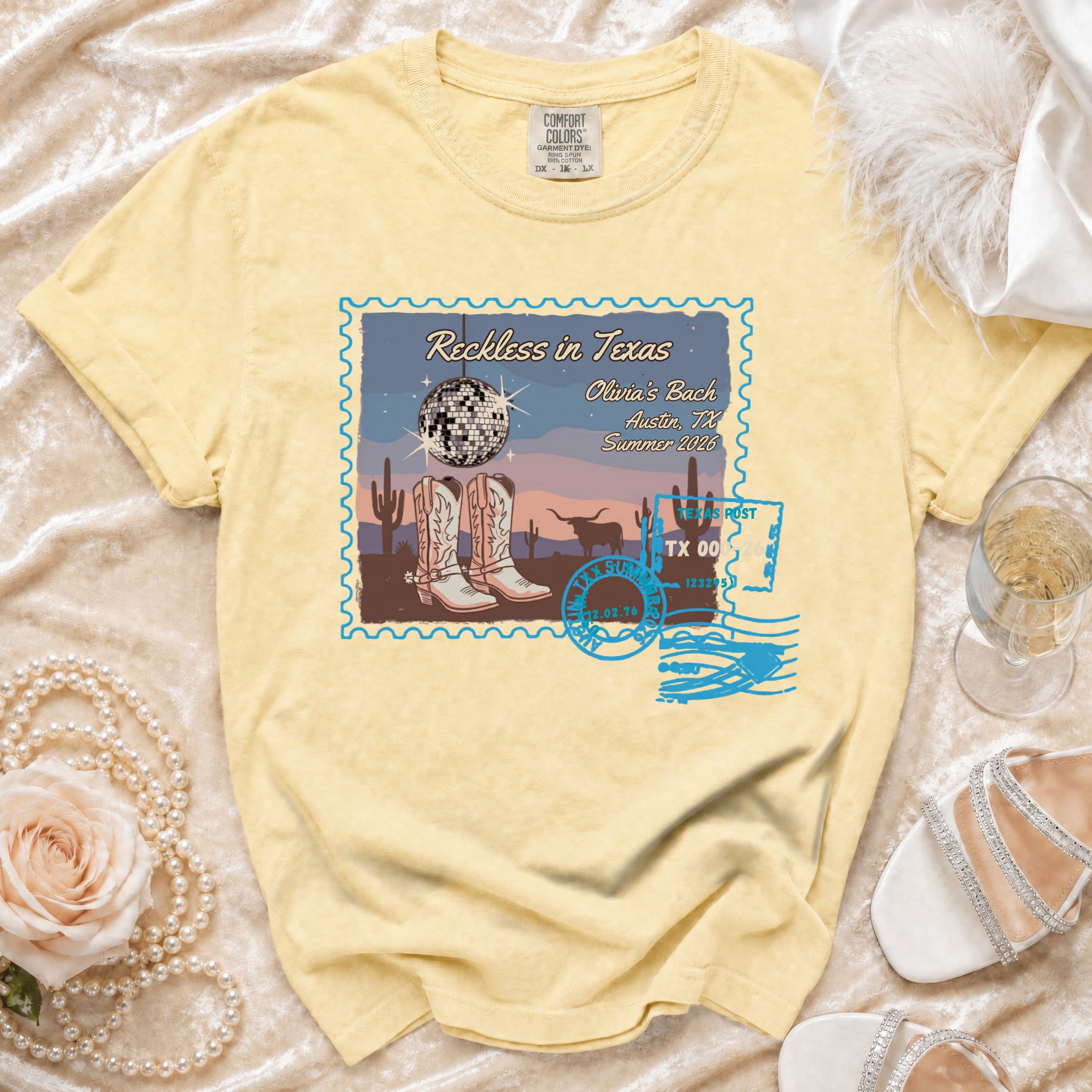 T-shirt with "Reckless in Texas" graphic featuring cowboy boots, disco ball, and cityscape.