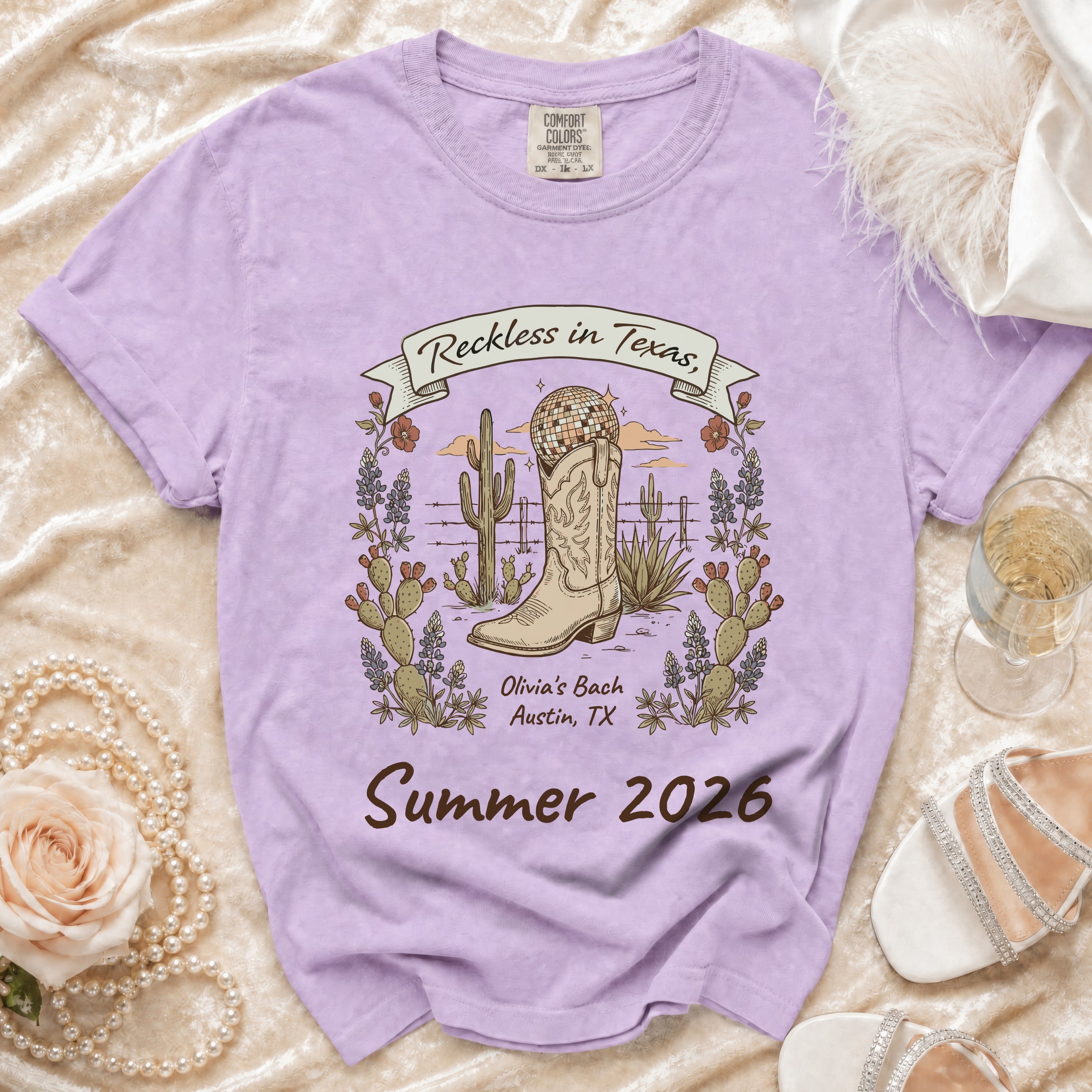 Purple t-shirt with "Reckless in Texas, Olivia's Bach Austin, TX Summer 2026" graphic.