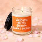 Candle with orange label reading "Welcome to My Dream Budget Wedding VOWED".