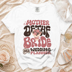 White t-shirt with "Mother of the Bride Wedding Planner" text in retro font.