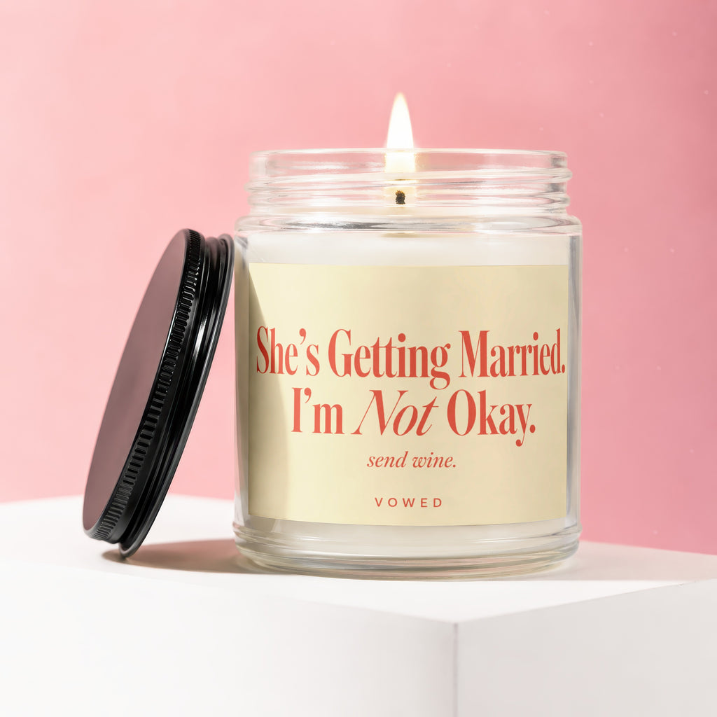 Lit candle in a jar with "She's Getting Married. I'm Not Okay. send wine. VOWED" text.