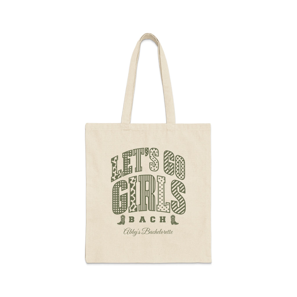 Beige canvas tote bag featuring green text that reads Lets Go Girls Bach Abbys Bachelorette.