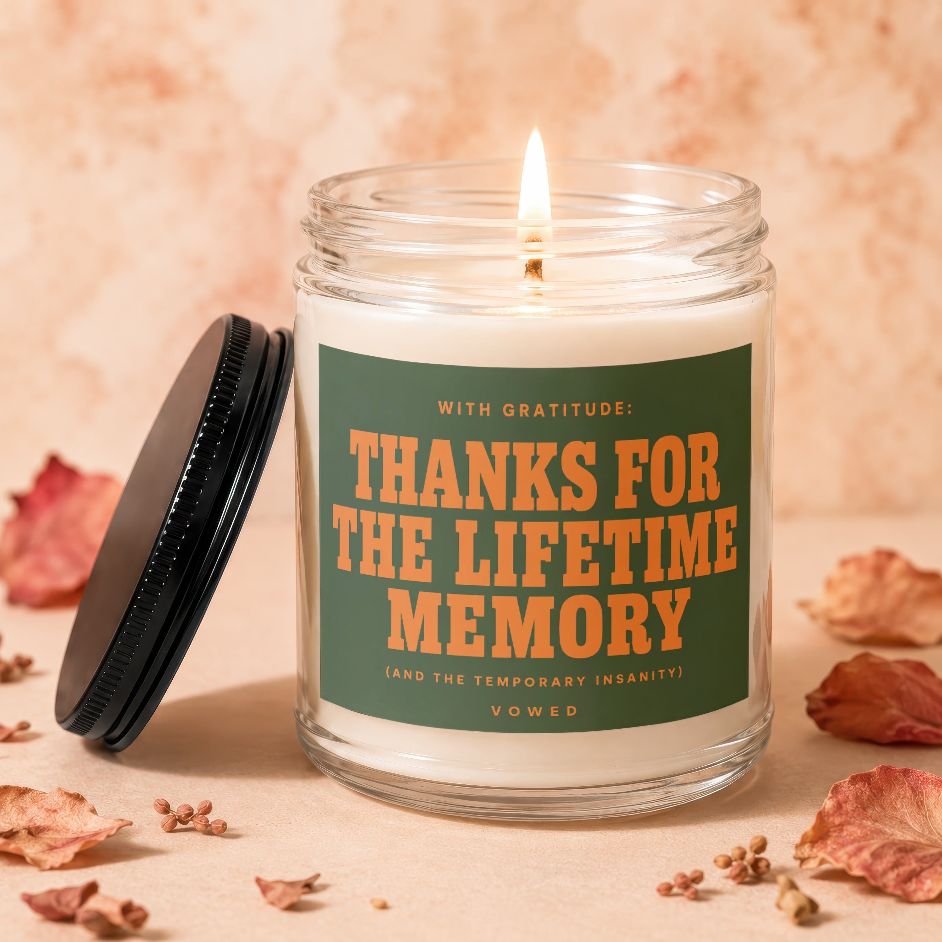 Candle with lit wick and black lid asks "Thanks for the lifetime memory."