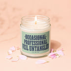 Lit candle in a jar with "Occasional Professional Veil Untangler" text and pink petals.