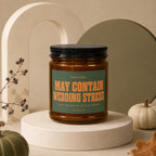 Candle labeled "MAY CONTAIN WEDDING STRESS" and "VOWED" with decorative elements.