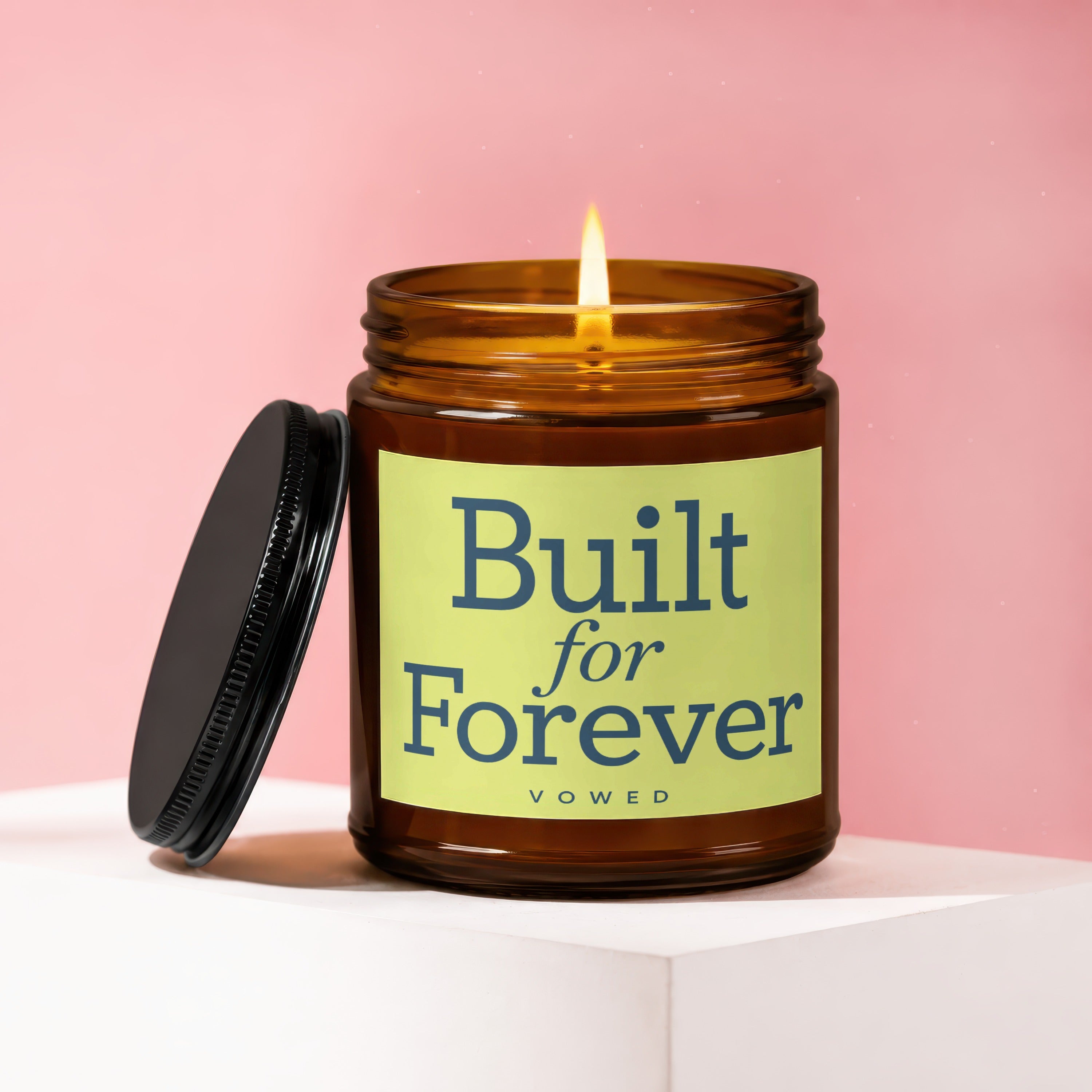 Amber jar candle with lit wick, black lid, and text "Built for Forever VOWED".